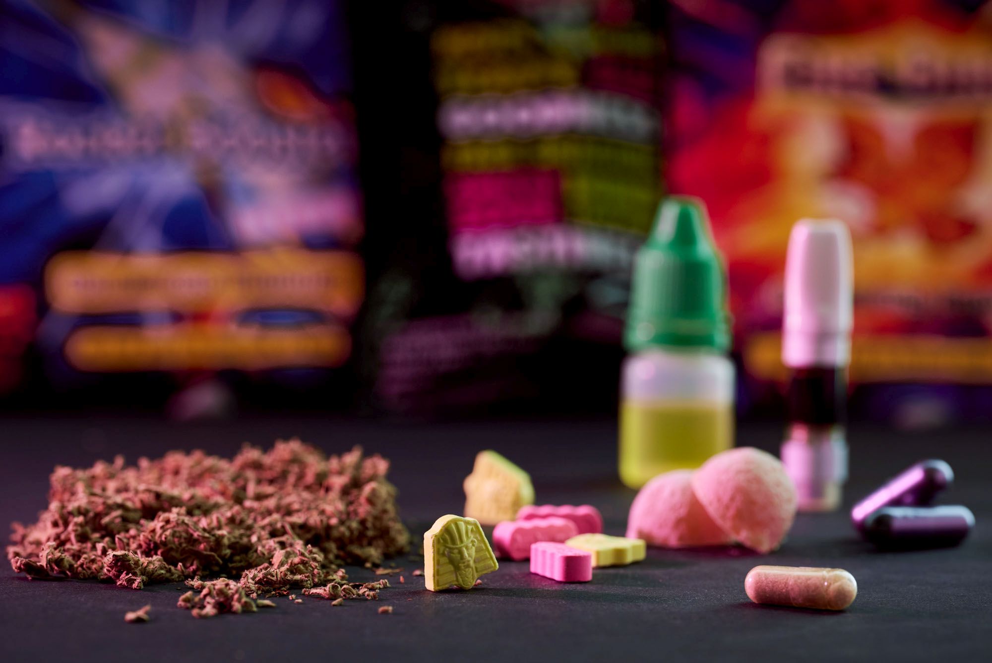 Various synthetic drugs in front of a colorful blurred background