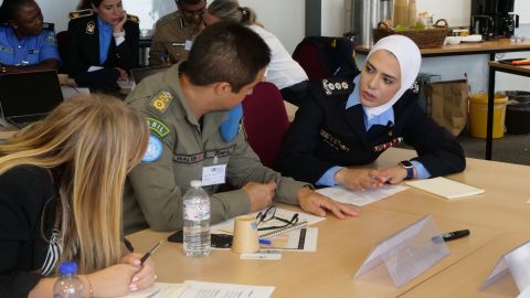 Three seminar participants sit at a table and discuss something.