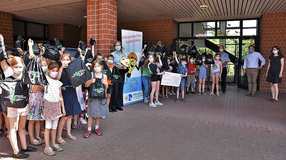 Gruppenbild mit der Gewinnerklasse des Namenswettbewerbs zum Maskottchen der Präventionskampagne "Helmpaten-Pass" 
